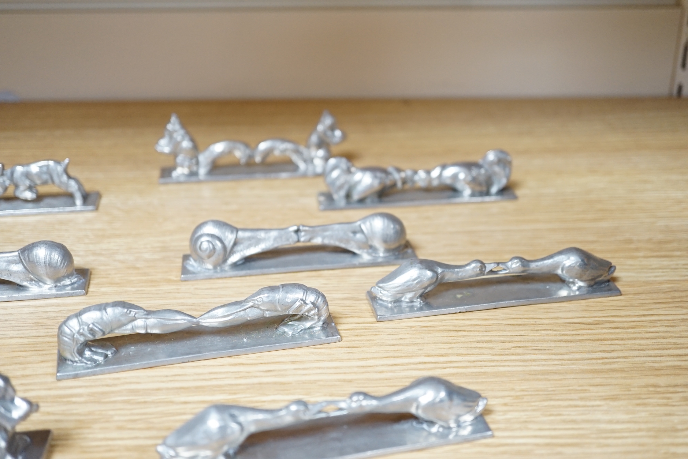 A set of 12 French pewter novelty knife rests, in the form of squirrels, fish, snails, goats, etc.